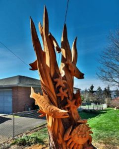 tree stump sculpture of swimming salmon and crab by Tomas Vrba of Bellingham