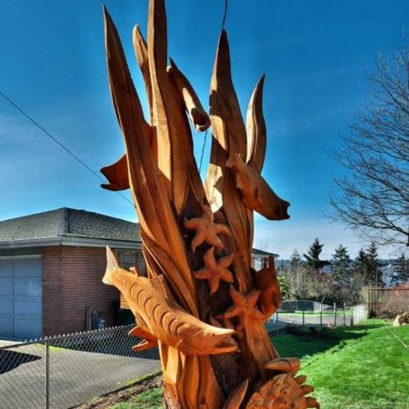 tree stump sculpture of swimming salmon and crab by Tomas Vrba of Bellingham